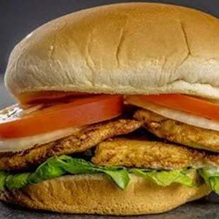 a chicken sandwich with tomatoes and lettuce