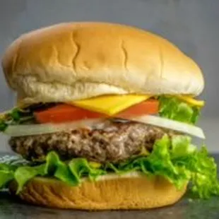 a hamburger with lettuce, tomato, cheese, and onion