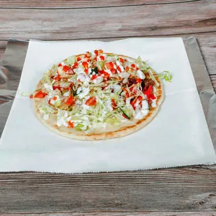 a flatbread pizza on a piece of aluminum foil