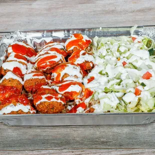 a container of meatballs and a salad