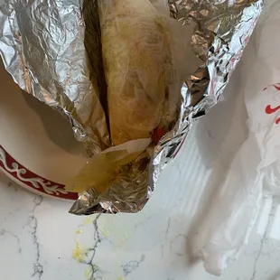 a sandwich wrapped in aluminum foil