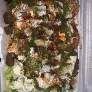 Lamb and falafel combo with salad and white, red, and green sauces