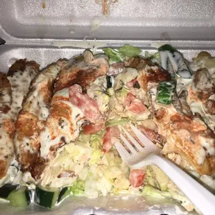 Fish over salad with white/hot sauce