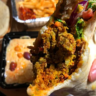 a hand holding a burrito