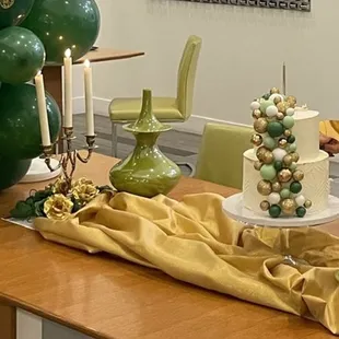 a table with a cake and balloons
