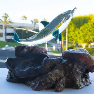 Glass dolphin atop manzanita.