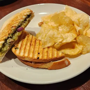 Chicken pesto panini sandwich and chips.