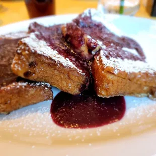 a plate of french toast with raspberry sauce