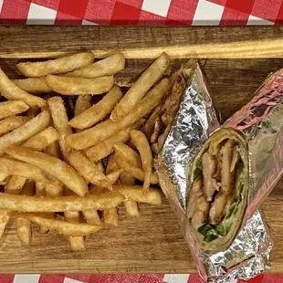 Grilled Chicken Wrap with fresh Lettuce, Tomato &amp; a Drizzle of greek savory sauce. Frenh Fries on the side.
