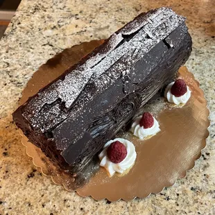 a chocolate cake with whipped cream and raspberries