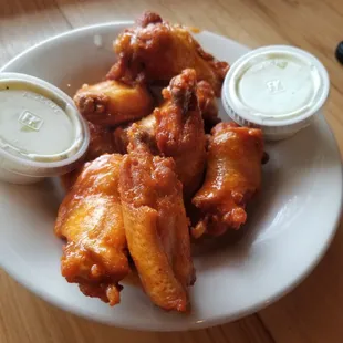 a plate of chicken wings with dipping sauce