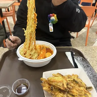 a man eating a bowl of noodles