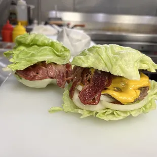 two burgers on a cutting board