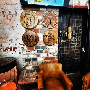 two chairs and a television in a brick walled room