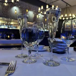 a table setting with wine glasses and silverware