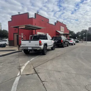 a line of trucks parked in front of a red building