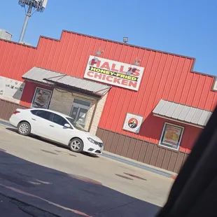 a white car parked in front of a red building
