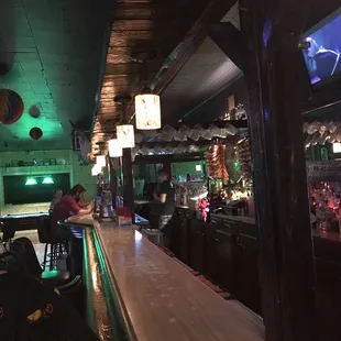 a bar with people sitting at the bar