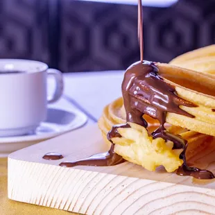 a waffle being dipped with chocolate