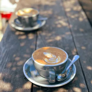 two cups of coffee on a wooden table