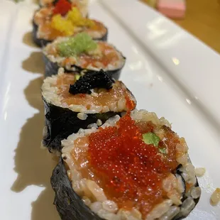 a row of sushi rolls on a white plate