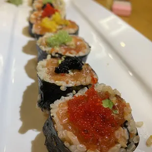 a row of sushi rolls on a white plate