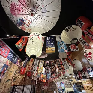 a variety of japanese umbrellas hanging from the ceiling