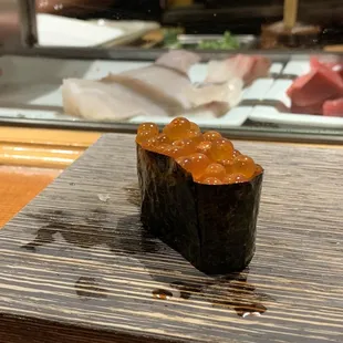 a piece of sushi on a chopping board