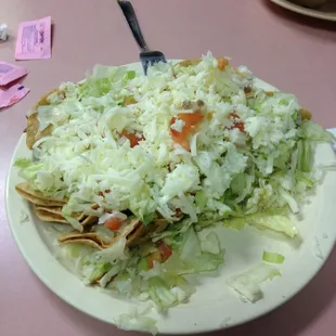 The dozen taquito salad, amazing plate at hamburger house. Somewhere underneath all that, lies a dozen taquitos.