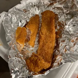 o pieces of fried chicken on tin foil