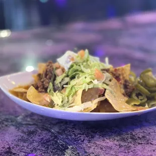 Diva Nachos! With cheddar cheese, ground beef, creamy nacho cheese, tomatoes, tangy jalapeños and cool sour cream