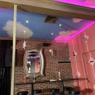 a brick wall with a mirror and bar stools