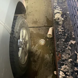 a dirty sidewalk and a dirty car