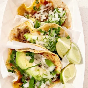 Tacos Pirata- Handmade corn tortillas, carne asada, oaxaca cheese, grilled onion, cilantro, and avocado.