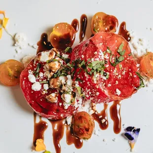 a plate of food with tomatoes and feta cheese