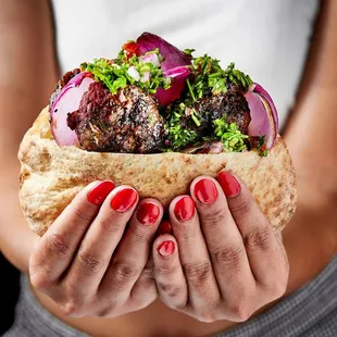 a woman&apos;s hands holding a sandwich