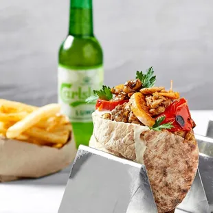 a pita and french fries with a bottle of beer