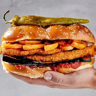 a chicken sandwich with pickles on top