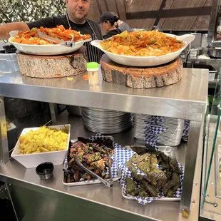 a man standing behind a buffet of food