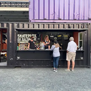 a couple of people standing at a bar