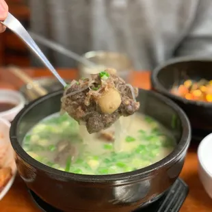 a bowl of soup with meat and vegetables