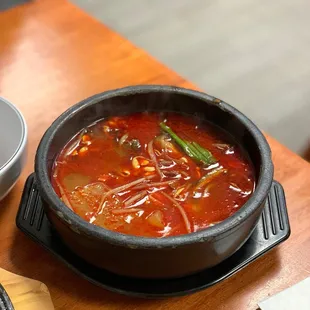 a bowl of soup and chopsticks on a table