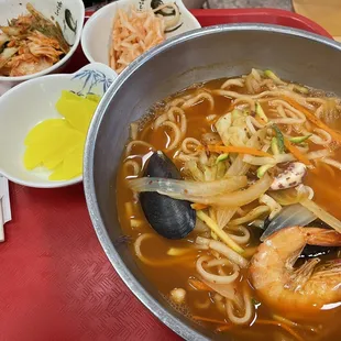 a bowl of soup with shrimp and noodles