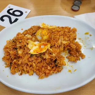 a plate of rice with an egg on top