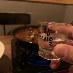 a hand holding a shot glass