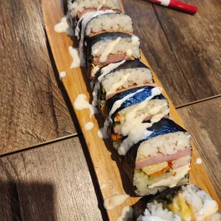 a long sushi roll on a wooden board