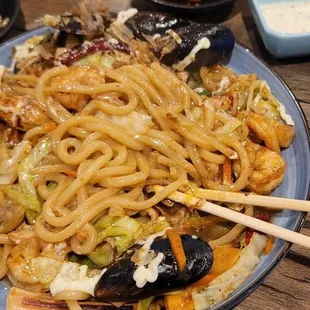 a plate of noodles and chopsticks on a table