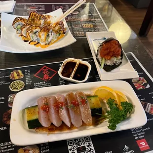 a plate of sushi and a bowl of sauce