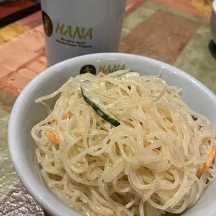 a bowl of noodles and a cup of green tea