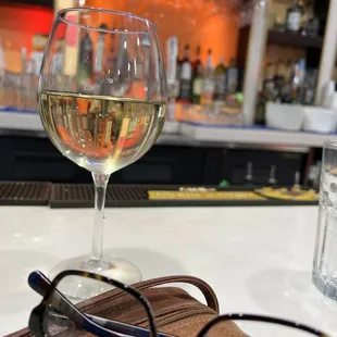 a glass of wine and a pair of glasses